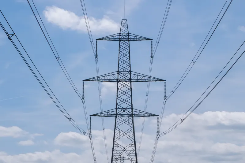 An electricity pylon with power lines fanning out overhead